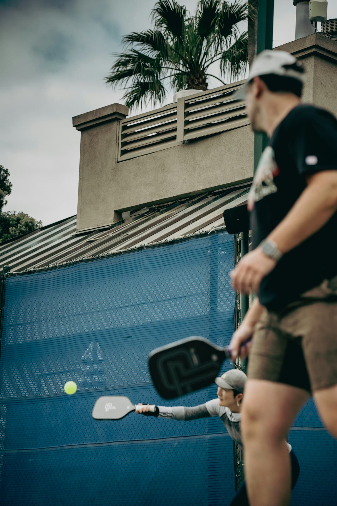 Players in a doubles game of pickleball on an outdoor court